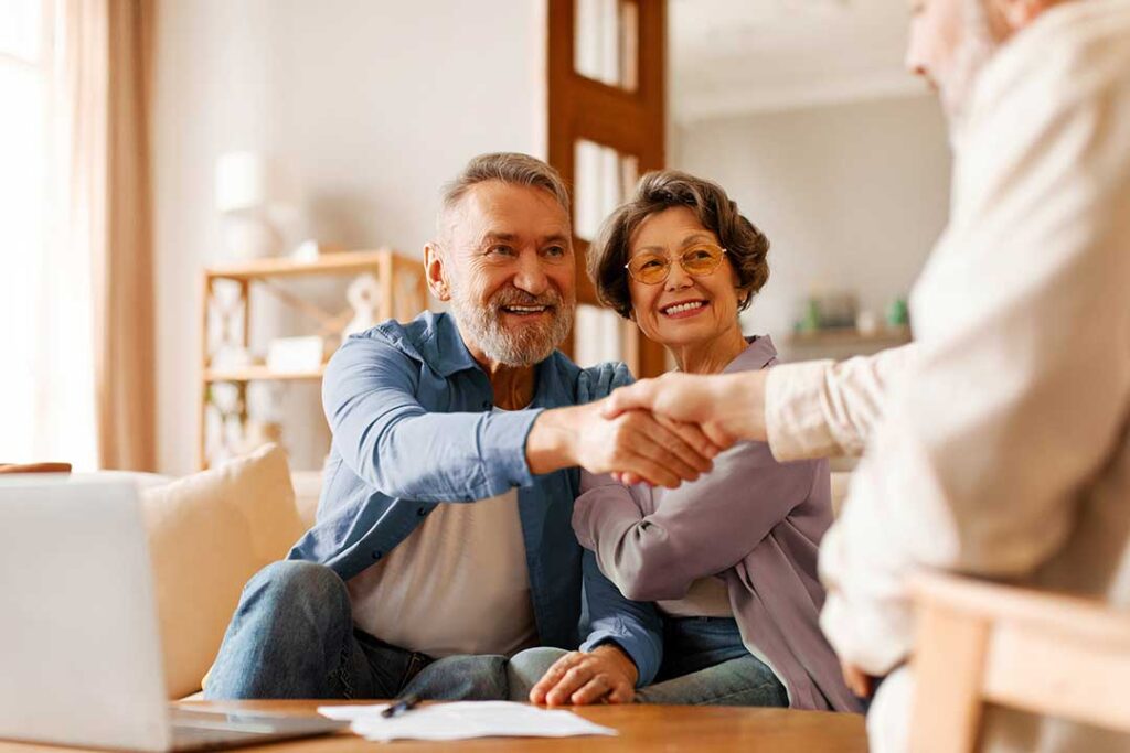 Family members review old financial records, bank statements, and insurance papers at a home table.